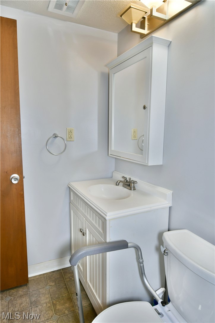 2980 North River Road Northeast, Unit E3 Warren, OH 44483 - Photo 21 of 27 Bathroom with toilet, a textured ceiling, tile floors, and oversized vanity