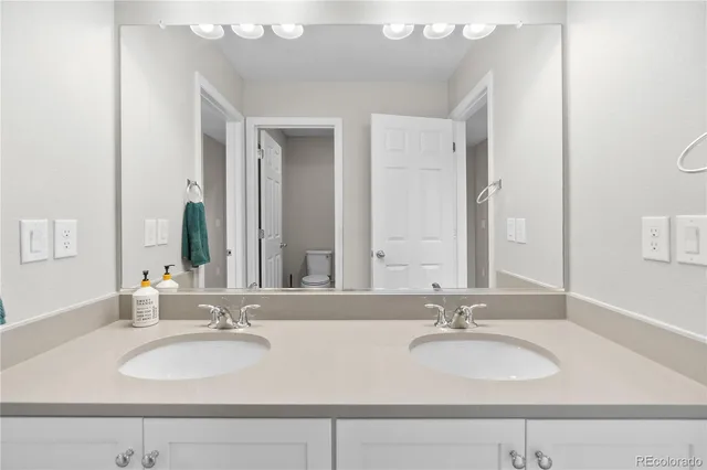 a bathroom with double vanity sinks and a mirror