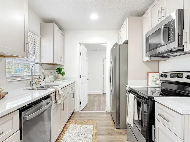 a kitchen with stainless steel appliances granite countertop a refrigerator stove and sink