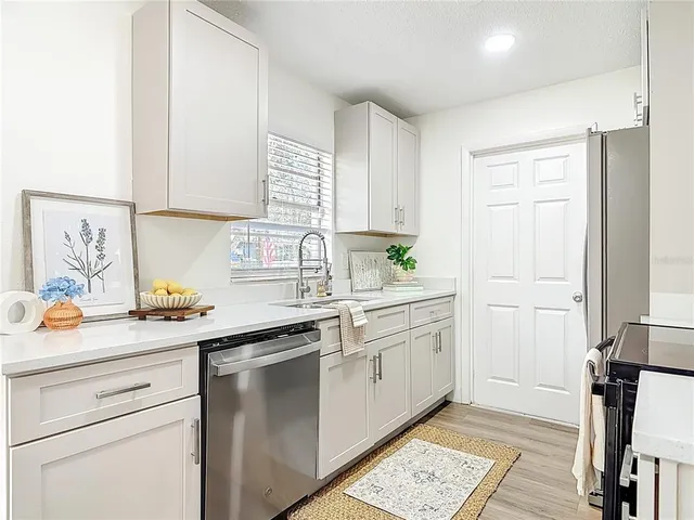 a kitchen with stainless steel appliances granite countertop a sink stove and cabinets