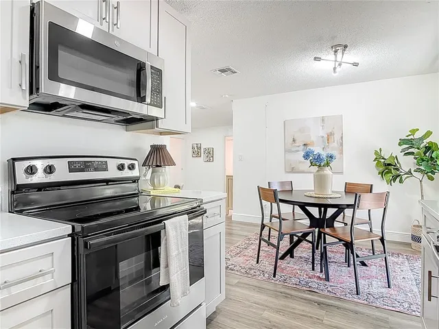 a kitchen with stainless steel appliances a stove microwave and cabinets