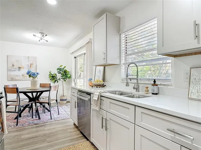 a kitchen with a table chairs and white cabinets