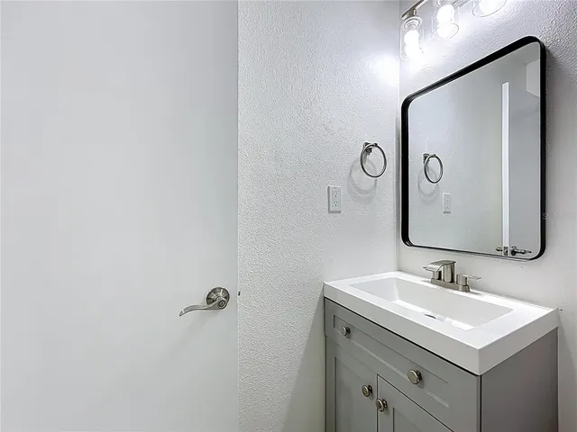 a bathroom with a sink vanity and a mirror