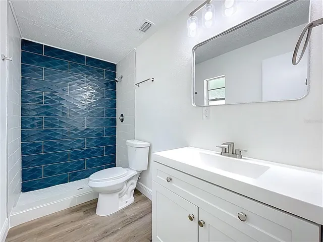 a bathroom with a sink a toilet and shower