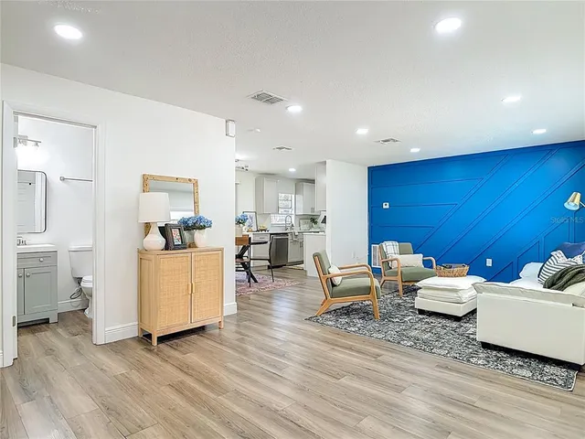 a living room with furniture and view of kitchen