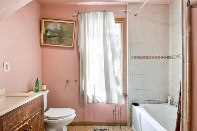 a bathroom with a granite countertop toilet a sink and a bathtub