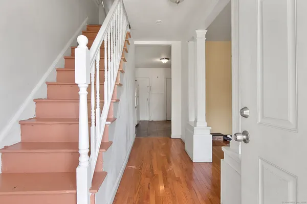 a view of a hallway with wooden floor and staircase