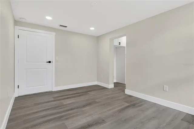 a view of an empty room with a window and a ceiling fan