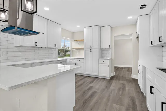 a kitchen with stainless steel appliances a refrigerator and a stove top oven