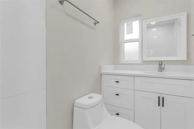 a white toilet sitting next to a shower
