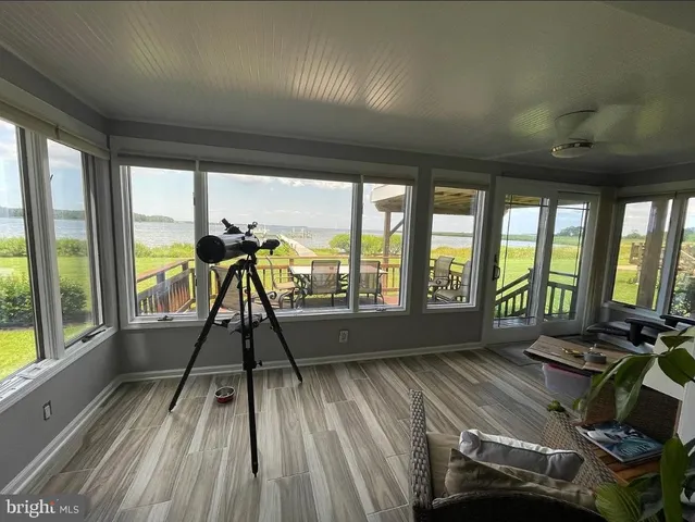 a view of empty room with wooden floor and floor to ceiling windows