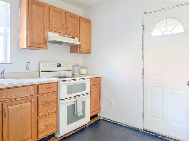 a kitchen with stainless steel appliances granite countertop white cabinets and a sink