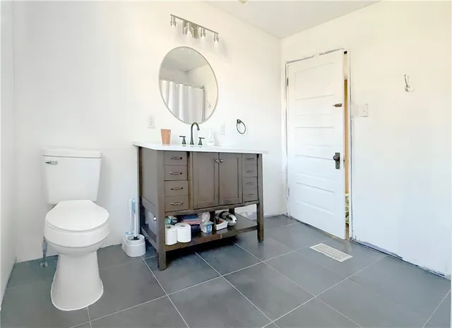 a bathroom with a toilet sink and mirror