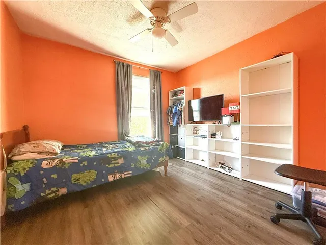 a bedroom with a bed and a bookshelf with wooden floor