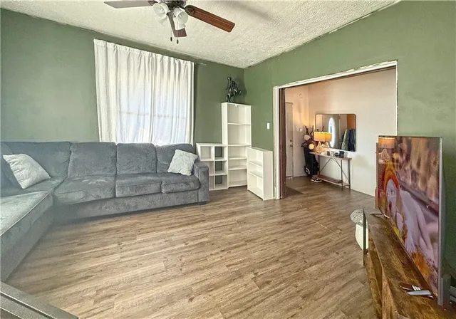 a living room with furniture and a wooden floor