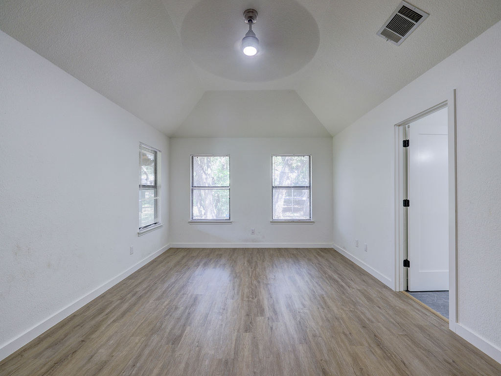 5842 Secrest Drive Austin, TX 78759 - Photo 19 of 40 A vaulted ceiling crowns this spacious room, illuminated by natural light through multiple windows.
