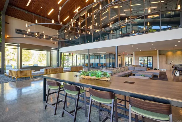 a room with lots of tables a large window and chairs