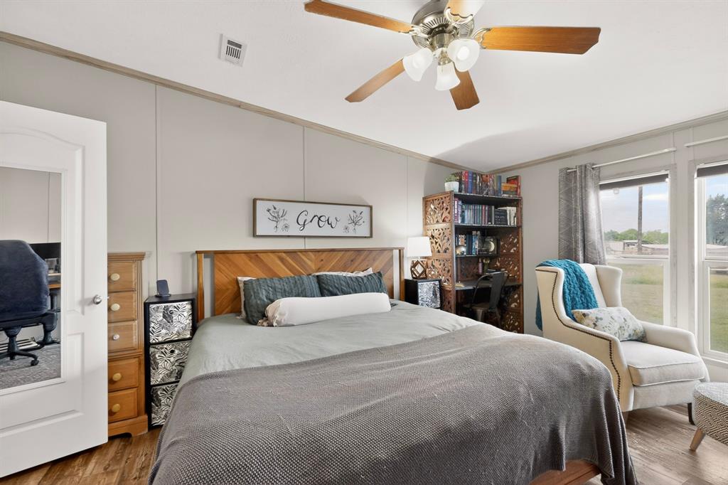 115 Vinall Circle Decatur, TX 76234 - Photo 11 of 23 a bedroom with a large bed and a chandelier