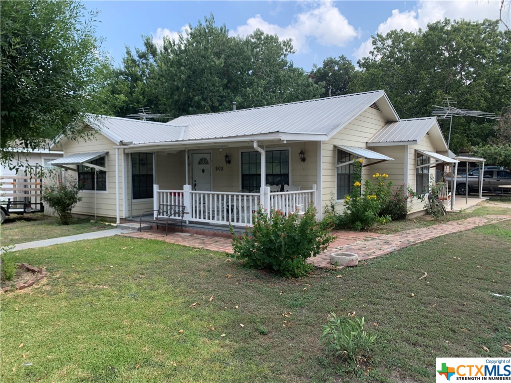 a view of a house with backyard and sitting area