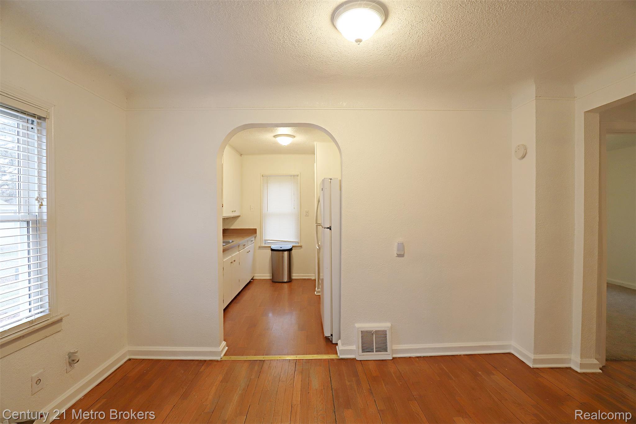 2074 North Center Road Burton, MI 48509 - Photo 6 of 20 Hall with light wood-type flooring, arched walkways, and a textured ceiling