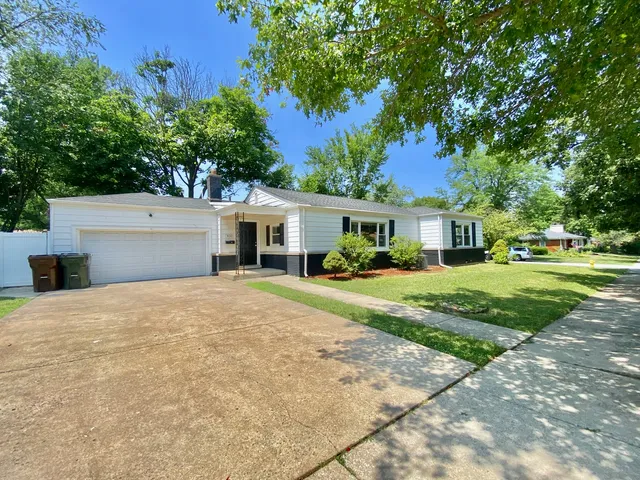 a front view of a house with a yard and trees