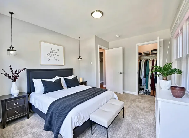 a bedroom with bed and a potted plant