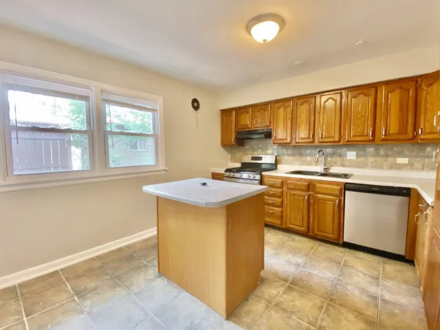 a kitchen with a sink window and cabinets