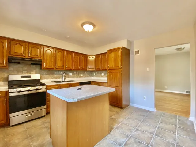 a kitchen with stainless steel appliances granite countertop a stove a refrigerator and a sink
