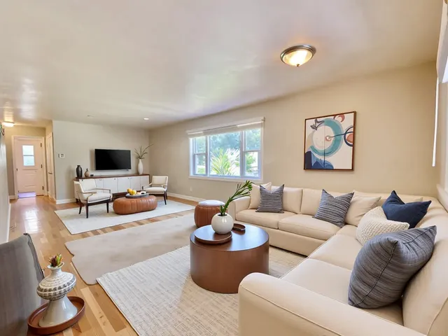 a living room with furniture wooden floor and a flat screen tv