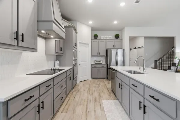a large kitchen with stainless steel appliances sink a microwave and cabinets