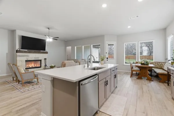 a large kitchen with a counter space a sink appliances and cabinets