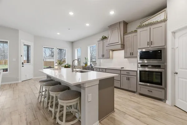 a kitchen with stainless steel appliances a sink stove and cabinets