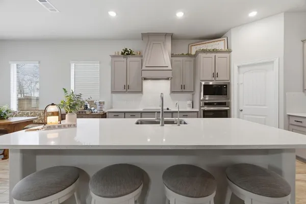 a kitchen with a sink a table and chairs