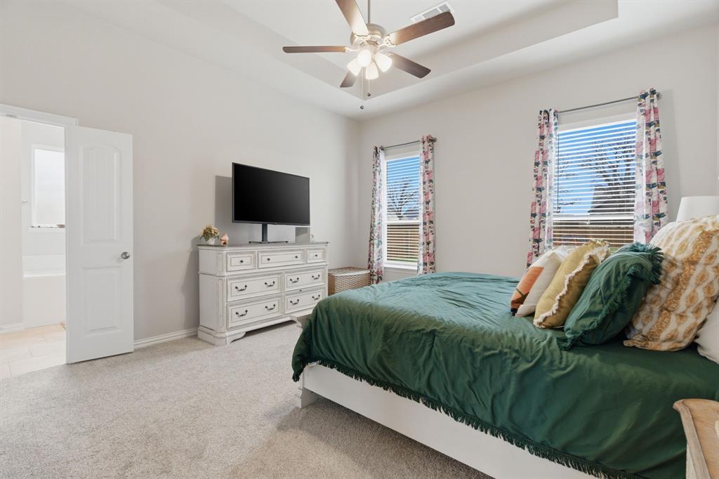 1117 Springfield Road Springtown, TX 76082 - Photo 19 of 40 a bedroom with a bed and a flat tv screen on dresser