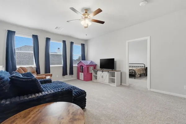 a bedroom with a bed and a flat tv screen on the dresser