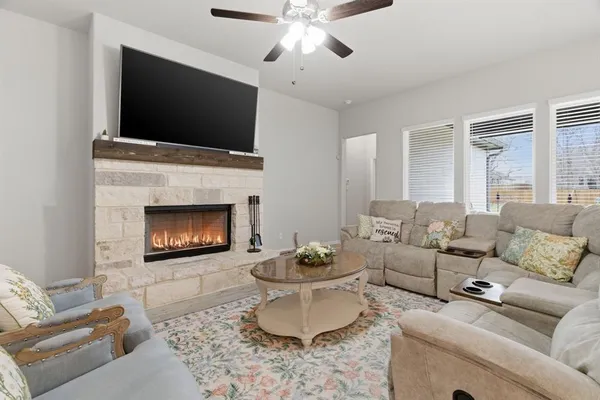 a living room with furniture a flat screen tv and a fireplace
