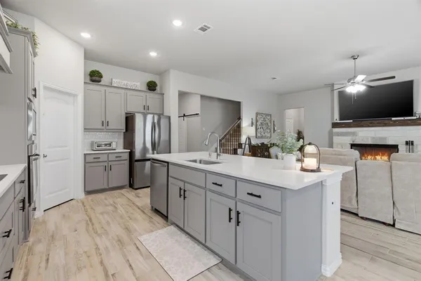 a kitchen with cabinets and wooden floor