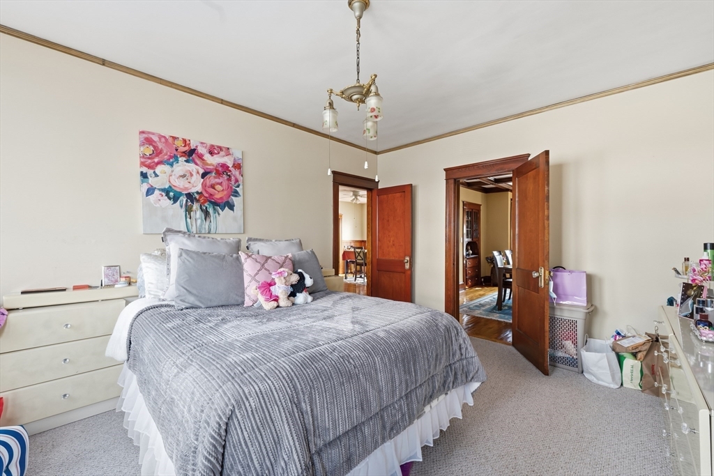 47 Houghton Street Worcester, MA 01604 - Photo 17 of 39 a bedroom with a bed and a chandelier