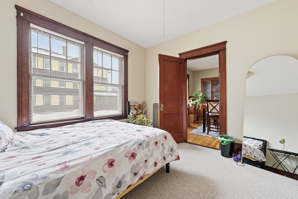 47 Houghton Street Worcester, MA 01604 - Photo 19 of 39 a bedroom with a bed a mirror and a large window