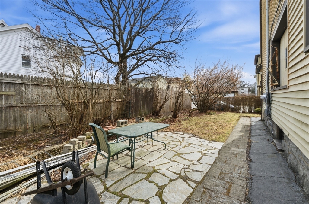 47 Houghton Street Worcester, MA 01604 - Photo 23 of 39 a view of backyard with table and chairs and wooden fence