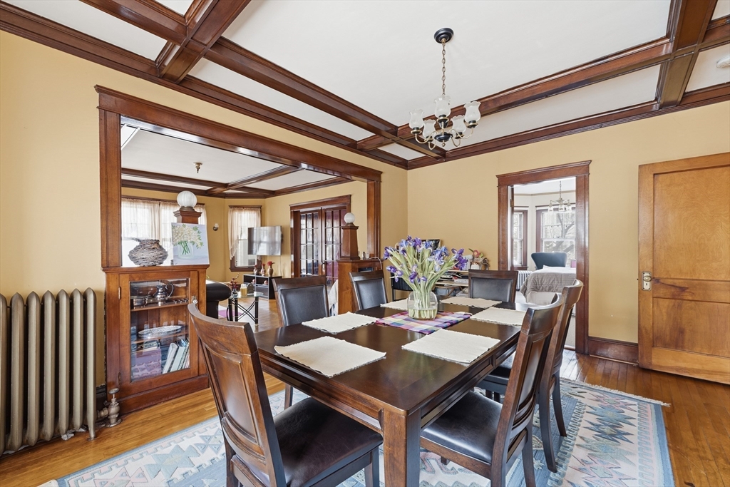47 Houghton Street Worcester, MA 01604 - Photo 9 of 39 a dining room with wooden floor a chandelier a wooden table and chairs