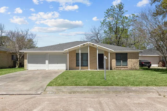 a front view of a house with a garden and trees