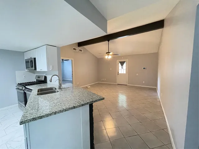 a kitchen with granite countertop a sink and a stove