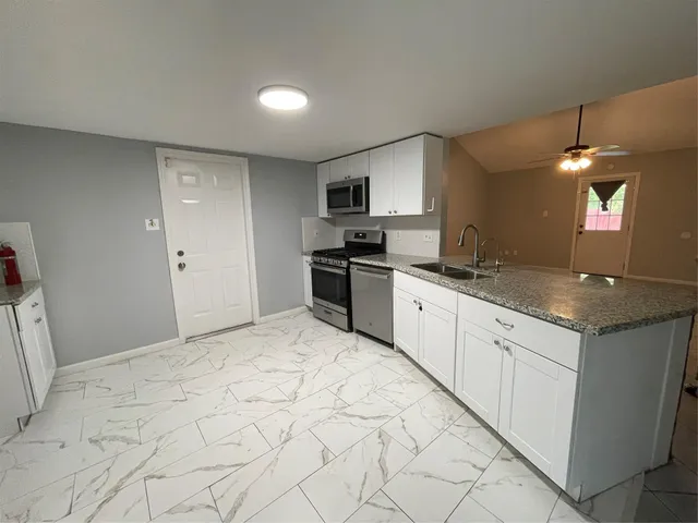 a kitchen with granite countertop a sink and cabinets