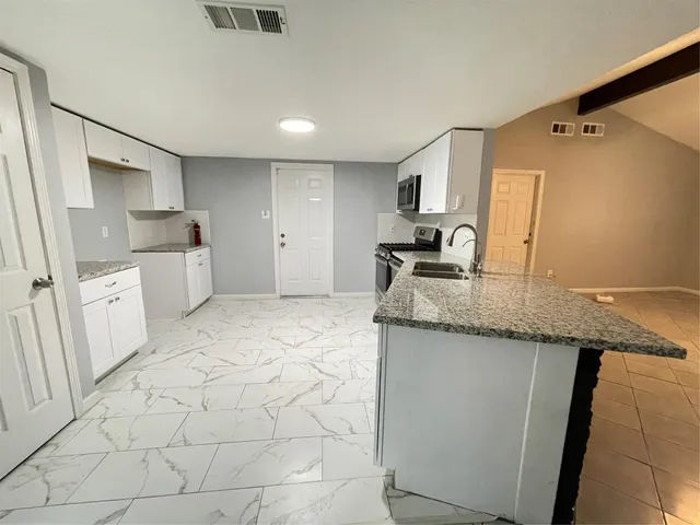 a kitchen with granite countertop a sink and cabinets