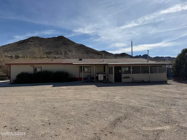 a front view of a house with a yard and mountain view