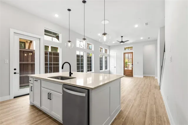a kitchen with stainless steel appliances granite countertop a sink a stove and a wooden floors