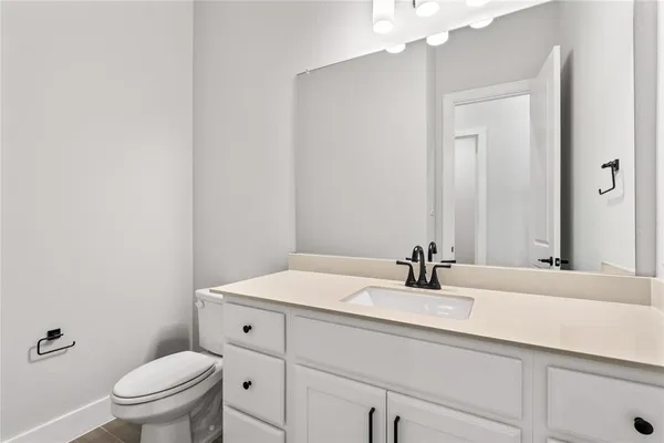 a bathroom with a sink a toilet and mirror