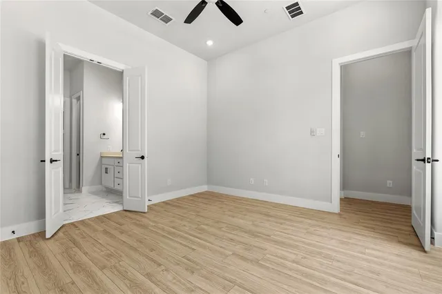 an empty room with wooden floor and bathroom space