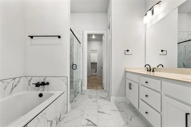 a spacious bathroom with a tub sink and mirror